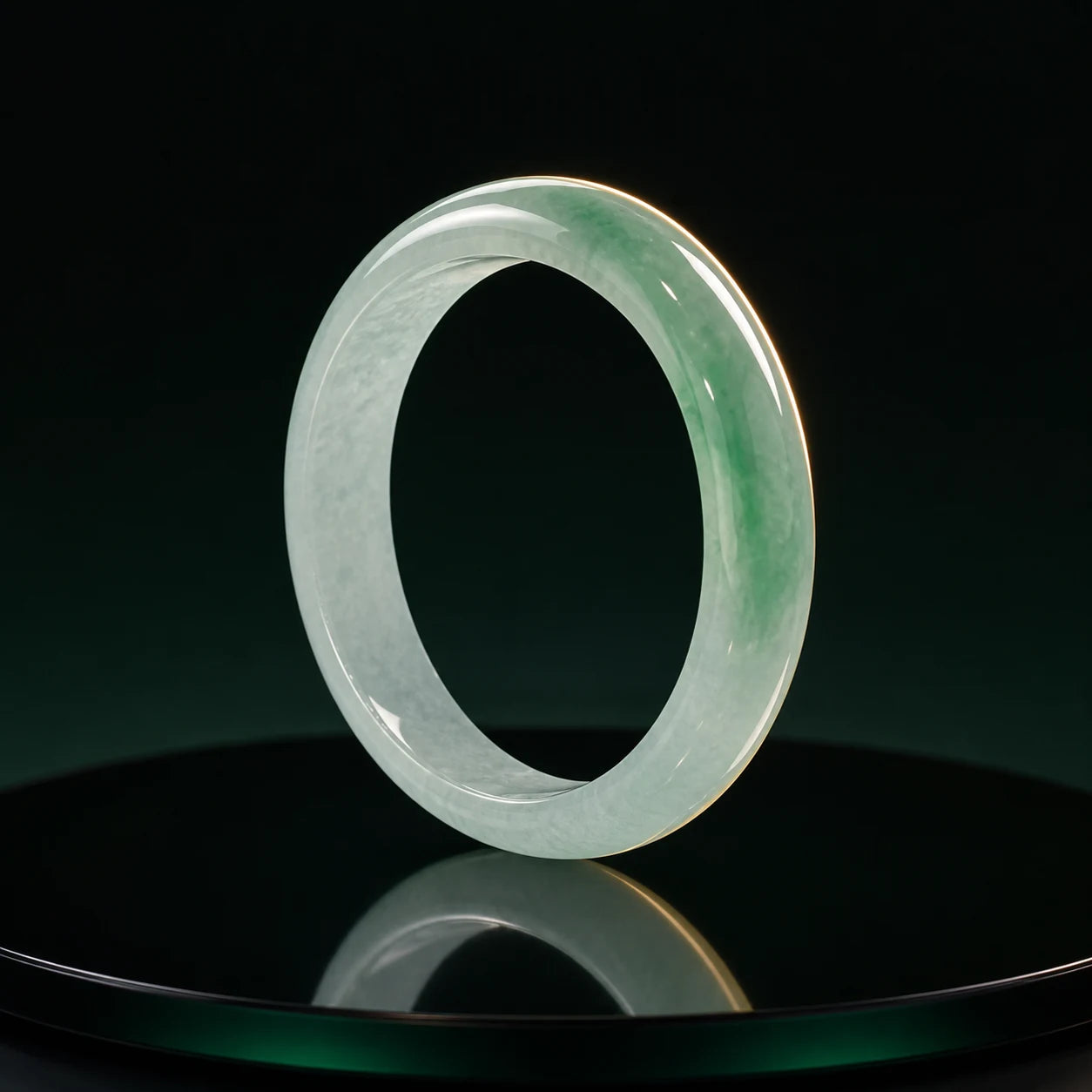 Pale green jade bangle on an obsidian mirror